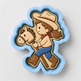 A cookie cutter in the shape of a cartoon girl riding a horse.