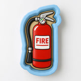 A fire extinguisher in a cookie cutter shape, with the word "FIRE" written on it.