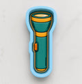 A blue and green flashlight-shaped cookie cutter is shown against a white background.