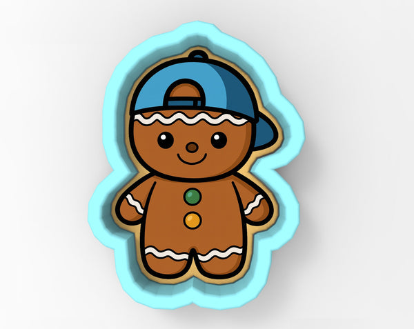 A cookie cutter in the shape of a gingerbread man wearing a blue baseball cap.