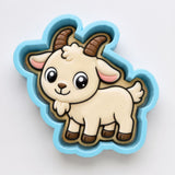 A cookie cutter in the shape of a cartoon goat with horns and a white body.