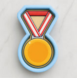 A blue cookie cutter shaped like a medal, with a yellow circle in the center.