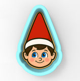 A cookie cutter in the shape of a smiling elf's face wearing a red hat.