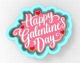 A heart-shaped cookie cutter with the text "Happy Galentine's Day" written on it in a cursive font.