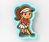 A cartoon image of a young girl wearing a red shirt and white skirt, holding a golf club and smiling.