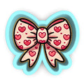 a paper cut out of a bow with hearts on it