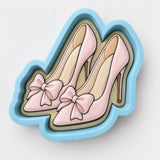A pair of pink high-heeled shoes with bows on the toe.