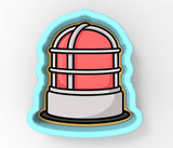A cookie cutter in the shape of a red and white striped object, possibly a lamp or a container, with a white base and a blue border.