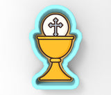 A cookie cutter in the shape of a cup with a cross symbol on top, representing a religious or spiritual symbol.