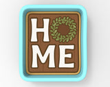 A square-shaped container with the word "HOME" written on it, along with a wreath design.
