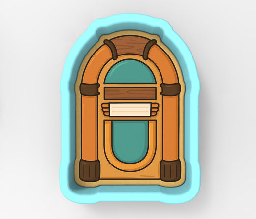 A jukebox cookie cutter in the shape of a jukebox, with a wooden frame and a turquoise background.