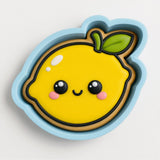 A cookie cutter in the shape of a smiling lemon with a leaf on top.
