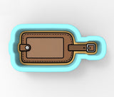 A blue and brown luggage tag with a leather strap, designed to fit inside a blue container.