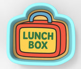 A lunch box-shaped cookie cutter with the text "LUNCH BOX" printed on it.