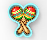 A pair of colorful maracas, a traditional Mexican musical instrument, are depicted in a heart-shaped cookie cutter.