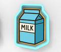A blue and white cookie cutter shaped like a carton of milk.