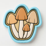 A cookie cutter in the shape of a mushroom, with three distinct mushroom-shaped pieces.