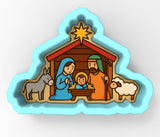 A 3D cookie cutter depicting a nativity scene with a baby Jesus, Mary, and Joseph, along with a donkey, sheep, and a star.