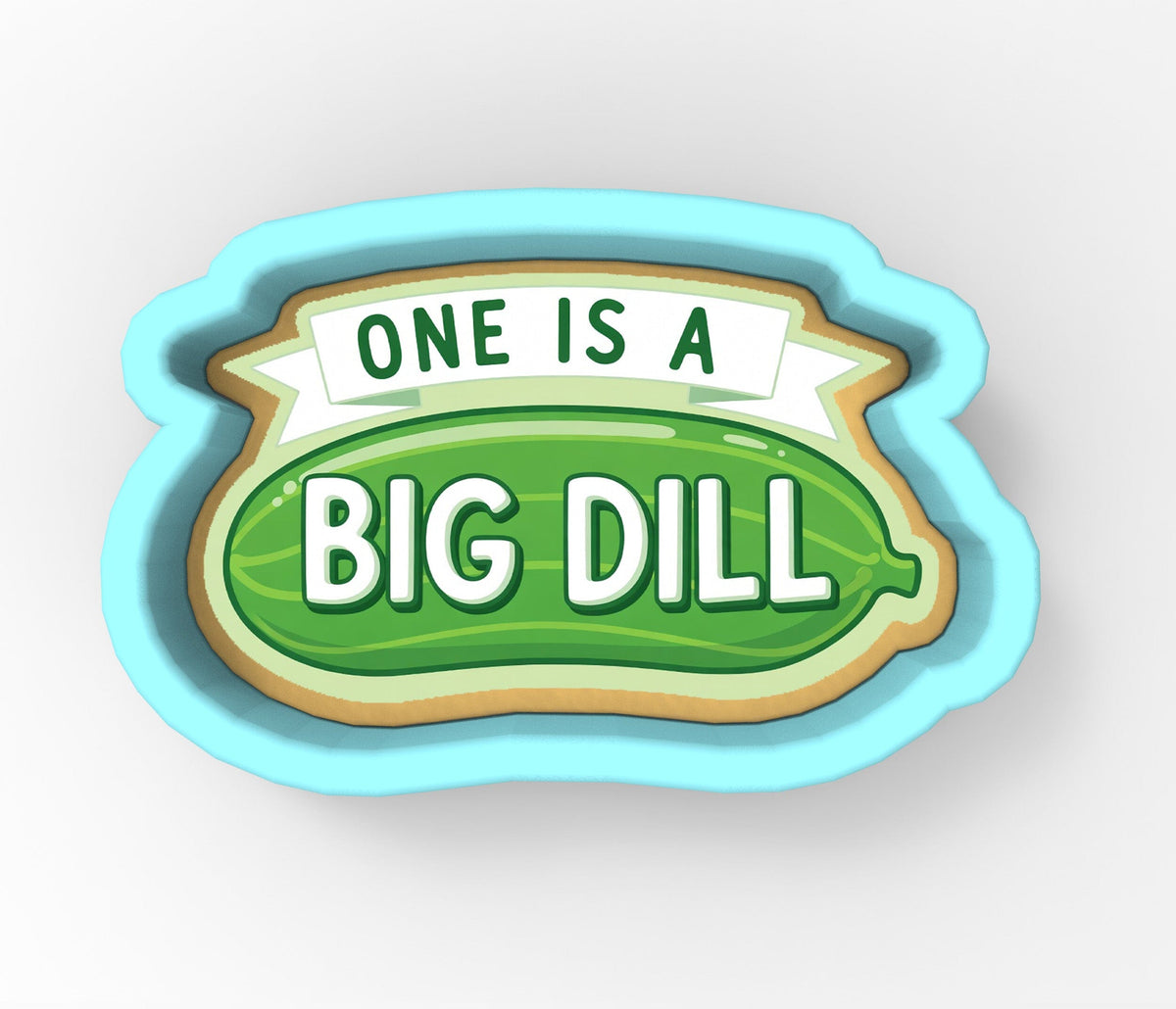 A cookie cutter shaped like a pickle with the text "ONE IS A BIG DILL" printed on it.