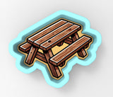 a wooden picnic table sitting on top of a blue cloud