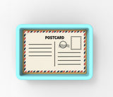 A rectangular, light blue tray with a white, postcard-style label on it.