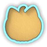 a cookie cutter with a cookie in the shape of a pumpkin