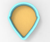 A blue-colored, teardrop-shaped cookie cutter with a yellow-colored interior.