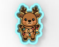 A cartoon reindeer cookie cutter with a string of colorful Christmas lights wrapped around it.