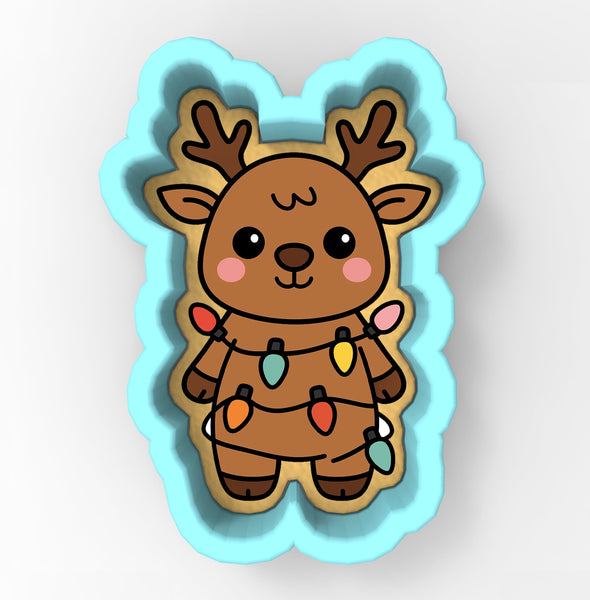 A cookie cutter in the shape of a reindeer, decorated with colorful Christmas lights.