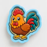 A cartoon image of a rooster in a blue and yellow cookie cutter.
