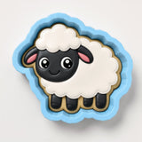 A cookie cutter in the shape of a sheep with a white body, black face, and pink ears.