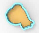 A cookie cutter in the shape of a bird, with a light brown color and a blue outline.