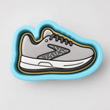 A 3D rendering of a gray and white sneaker with a blue outline, set against a plain white background.