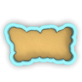 a dog bone shaped cookie cutter with a light blue background