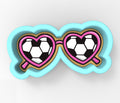 A pair of heart-shaped sunglasses with a soccer ball pattern on the lenses.