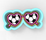 A pair of heart-shaped sunglasses with a soccer ball pattern on the lenses.
