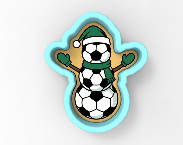 A cookie cutter in the shape of a snowman, with a soccer ball as its head and a scarf around its neck.