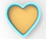 A heart-shaped container made of a light-colored material, possibly a ceramic or plastic material, with a blue border.