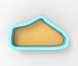 A blue-bordered, triangular-shaped object made of a light-colored material, possibly sand or clay.