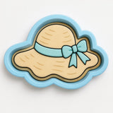 A blue and yellow cartoon-style hat with a bow, designed as a cookie cutter or mold.