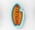 A blue-bordered cookie cutter shaped like a surfboard with yellow flowers on it.