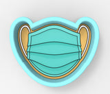 A blue and gold cookie cutter shaped like a face mask.