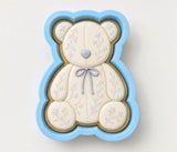 A blue and white teddy bear cookie cutter with a floral design on it.