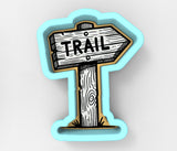 a wooden sign with the word trail painted on it