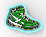 A green and white sneaker-shaped cookie cutter.
