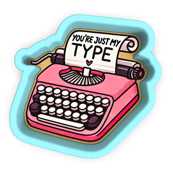 a pink typewriter with a sign that says you're just my type