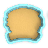 a cookie cutter with a cookie in the shape of a face